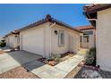 Exterior view showcasing the side of the townhome with a two-car garage, tile roof and gated entryway at 445 Intrepid Ct, Boulder City, NV 89005