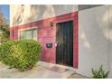 Front entry to the townhome featuring a secure gate and well-kept landscaping at 565 Greenbriar Townhouse Way, Las Vegas, NV 89121