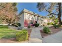 View of the townhome showcasing its tidy lawn, mature trees, and attractive landscaping at 565 Greenbriar Townhouse Way, Las Vegas, NV 89121