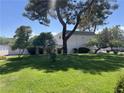 Lush green lawn with mature trees provides a serene and inviting landscape at 565 Greenbriar Townhouse Way, Las Vegas, NV 89121
