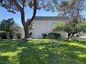Expansive green lawn, shaded by mature trees offering a tranquil and picturesque setting at 565 Greenbriar Townhouse Way, Las Vegas, NV 89121