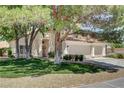 Charming home with mature trees, well-maintained lawn, and a spacious three-car garage at 5908 Marbrisas Ln, Las Vegas, NV 89130