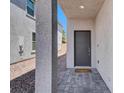 Home entrance featuring a gray modern front door, concrete pillar and stone pavers at 66 Chelsea Manor Ct, Las Vegas, NV 89110