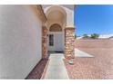Inviting front entrance with an arched doorway and stone accents at 690 Great Dane Ct, Henderson, NV 89052