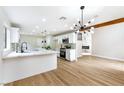 Open kitchen featuring white cabinets, eat-in island, marble fireplace, and modern lighting at 8113 Bay Springs Dr, Las Vegas, NV 89128