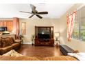 Cozy living room with a large window, ceiling fan, wood floors, and comfortable seating at 8316 Mokena Ave, Las Vegas, NV 89178
