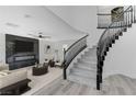 Bright foyer featuring a curved staircase with black rails, flowing into the open-concept living area at 9541 Summersweet Ct, Las Vegas, NV 89123