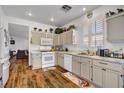 Bright kitchen with wooden floors, white cabinets, and stainless steel appliances at 1008 Welkin St, Henderson, NV 89052