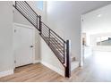 Bright entryway showcases the staircase with wood trim and modern metal railing at 10184 Juniper Valley St, Las Vegas, NV 89166