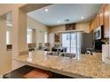 Granite counters and stainless appliances are featured in this kitchen with island and slider to the back yard at 10583 Mann St, Las Vegas, NV 89141