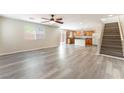 Bright, open-concept living area with wood-look floors and a ceiling fan, flowing into the kitchen at 10717 Red Badge Ave, Las Vegas, NV 89166