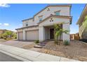 Charming two-story home with brick driveway and a three-car garage in a desert landscape at 1075 Page Park Ln, Henderson, NV 89011