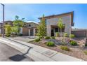 Modern home with desert landscaping, three-car garage, and a welcoming stone-accented entrance at 12332 Switchgrass Ave, Las Vegas, NV 89138
