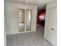 A bright entry featuring tile flooring, neutral walls, and mirrored closet doors at 1674 Seneca Ln, Las Vegas, NV 89169