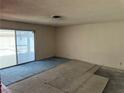 Empty living room with sliding glass doors and incomplete flooring installation at 1674 Seneca Ln, Las Vegas, NV 89169