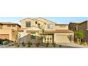 Inviting two-story home featuring neutral stucco, tiled roof, manicured landscaping, and a convenient two-car garage at 230 Cactus Sunrise St, Las Vegas, NV 89138