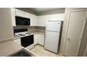 Well-lit kitchen includes white cabinets and appliances at 2300 E Silverado Ranch Blvd # 1104, Las Vegas, NV 89183