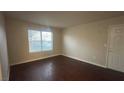 A bright living room with dark wood-look flooring, window and door at 2300 E Silverado Ranch Blvd # 1104, Las Vegas, NV 89183