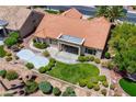 This home features a well-manicured backyard with lush landscaping, a covered patio, and a custom concrete pad at 2808 Crown Ridge Dr, Las Vegas, NV 89134
