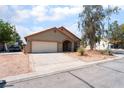 A single-story home featuring a two-car garage, a clean driveway, and desert landscaping at 4335 Twin Peaks Dr, North Las Vegas, NV 89032