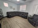 A beautifully staged living room featuring a large sectional, tile floors, and ample natural light at 5419 Brass Hills Ct, Las Vegas, NV 89122