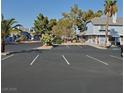 A well-maintained parking lot in front of a charming building with desert landscaping and palm trees under a clear blue sky at 5841 Medallion Dr # 102, Las Vegas, NV 89122