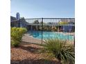 Community pool with a black fence and green landscaping around the area at 5841 Medallion Dr # 102, Las Vegas, NV 89122