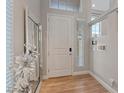 Bright foyer featuring wood-look floors, neutral paint, a sizable mirror, and a window allowing natural light at 6056 Atlantis Dream Ave, Las Vegas, NV 89139