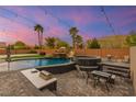 Backyard oasis with a swimming pool featuring a rock waterfall, spa, built-in grill, and lush landscaping at 6351 Abacus Farms Ct, Las Vegas, NV 89131