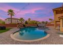 Backyard with a luxurious pool, rock waterfall, spa, and lush landscaping offering a serene outdoor space at 6351 Abacus Farms Ct, Las Vegas, NV 89131