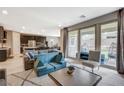An open-concept living room flows into a kitchen featuring sleek cabinetry and a stainless steel refrigerator at 8531 W Oquendo Rd, Las Vegas, NV 89113