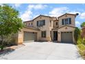 Two-story home with a desert landscape, two car garage, and a large driveway at 9319 White Waterfall Ave, Las Vegas, NV 89149