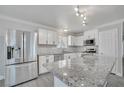 Modern kitchen with stainless steel appliances, white cabinetry, and granite countertops at 2880 Placita Ct, Las Vegas, NV 89121
