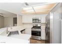 Efficient kitchen with stainless steel appliances, white cabinetry, and wood-look flooring at 2924 Pleasant Lake Dr, Las Vegas, NV 89117