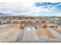 Single-story home showcasing a three-car garage and desert landscape, surrounded by neighborhood homes at 4801 Stoneham, Pahrump, NV 89061