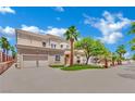 Two-story stucco home with a two-car garage, desert landscaping, palm trees, and a circular driveway on a sunny day at 5015 Thunder River Cir, Las Vegas, NV 89148