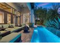 Inviting covered patio with plush seating area and an outdoor linear pool featuring cascading water features at 51 Avenida Sorrento, Henderson, NV 89011