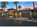 Beautiful desert home boasting a stone turret, manicured landscaping, and a brick driveway leading to a two-car garage at 51 Avenida Sorrento, Henderson, NV 89011