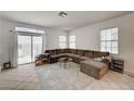 Bright living room featuring a comfortable sectional sofa, tile floors, and sliding glass doors leading to outdoor space at 7616 Yondering Ave, Las Vegas, NV 89131