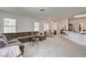 Spacious living room with neutral tile flooring, large sectional sofa, and abundant natural light, perfect for entertaining at 7616 Yondering Ave, Las Vegas, NV 89131