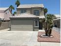 Two-story home with desert landscaping, garage, and light colored tiled roof at 8068 Cetus Cir, Las Vegas, NV 89128