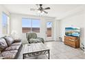 Bright living room featuring tile floors, large windows, and cozy seating arrangements at 8341 Lower Trailhead Ave, Las Vegas, NV 89113