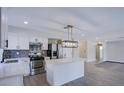 Bright kitchen features white cabinets, an island with a quartz countertop, and stainless-steel appliances at 836 Cherry Dr, Henderson, NV 89002