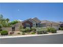 Charming home with a three-car garage, brick detailing, and desert-friendly landscaping at 905 Star Pine Dr, Las Vegas, NV 89144