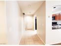 Inviting hallway with neutral walls, light tile flooring, and an open view into the kitchen area at 9069 Tantalizing Ave, Las Vegas, NV 89149