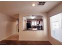 View of a living room with an archway leading to a kitchen with dark cabinets and countertops at 9069 Tantalizing Ave, Las Vegas, NV 89149