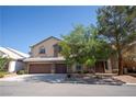 Two-story home with a three-car garage and mature tree in the front yard at 9660 Drayton Ave, Las Vegas, NV 89148