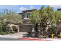 Charming two-story home showcasing a well-manicured yard with mature trees, neutral color palette, and an attached two-car garage at 9950 Coyote Echo Ct, Las Vegas, NV 89166