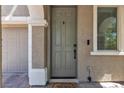 Inviting front door with sidelight and matching hardware, set in stucco exterior with brick pavers and column at 9950 Coyote Echo Ct, Las Vegas, NV 89166