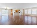 Open floor plan living room with wood floors that flows into the kitchen at 11577 Vesuvio Ct, Las Vegas, NV 89183